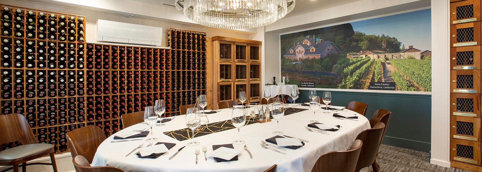 Private dining room with wine cellar, glass chandelier and table set for 12.