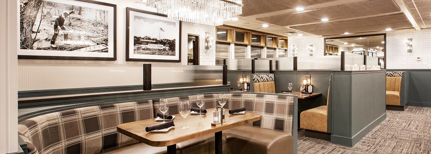 Open dining room area with booth seating and black and white large photography on walls.
