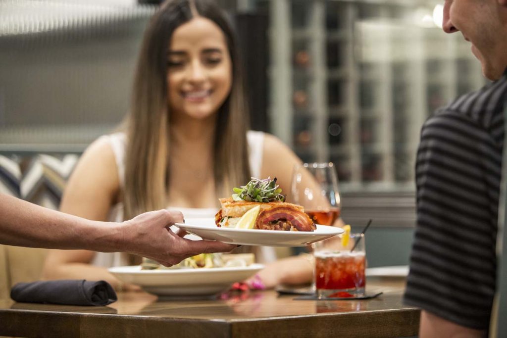 Woman smiles as entree is presented to her