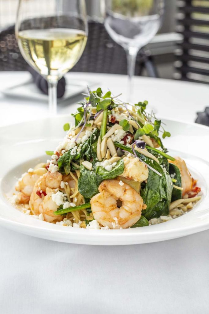 Tucci’s Shrimp with orzo pasta topped with salad greens