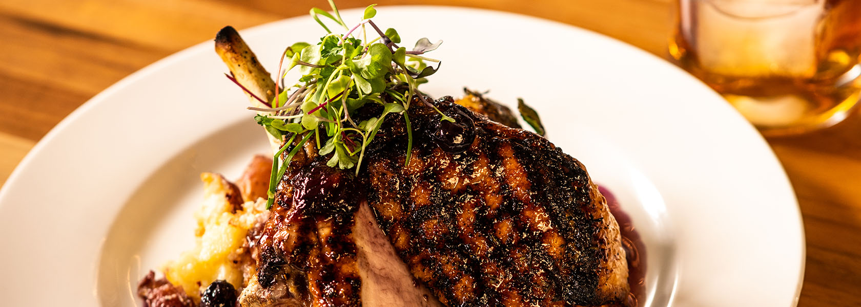 Berkshire Pork Chop presentation with bourbon cocktail at Tucci's in Dublin, Ohio.