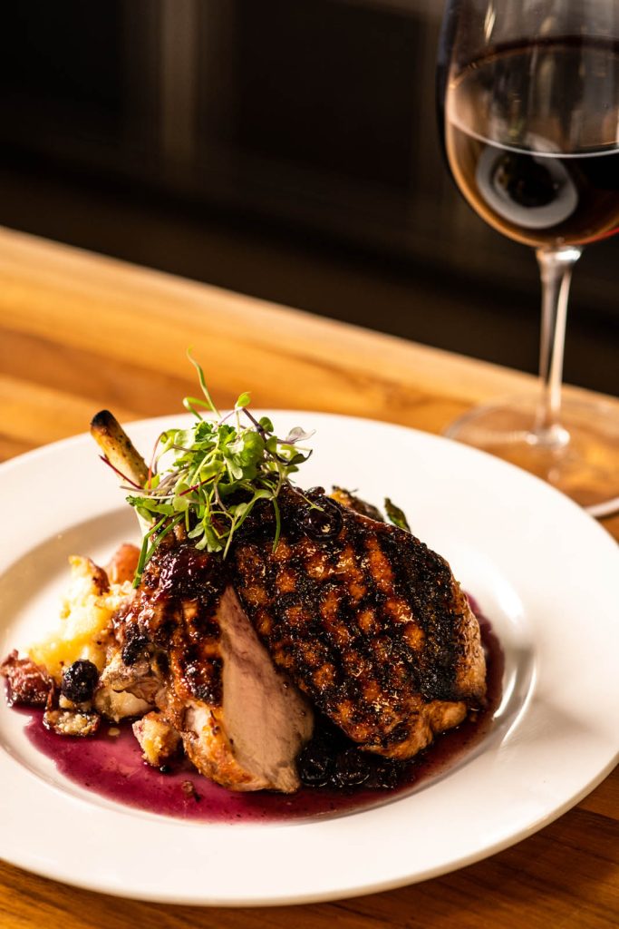 Berkshire Pork Chop with glass of wine at Tucci's restaurant in Dublin, Ohio.