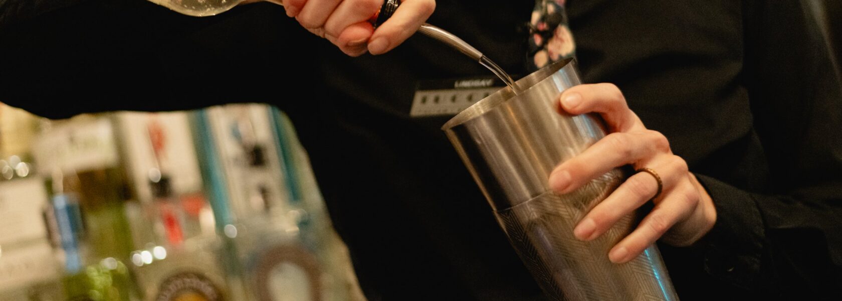 A bartender shaking a cocktail at Tucci's bar