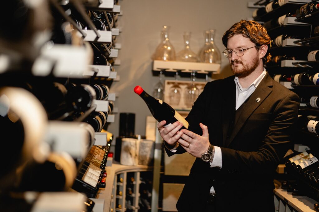 Tucci's sommelier presenting a bottle in the wine cellar