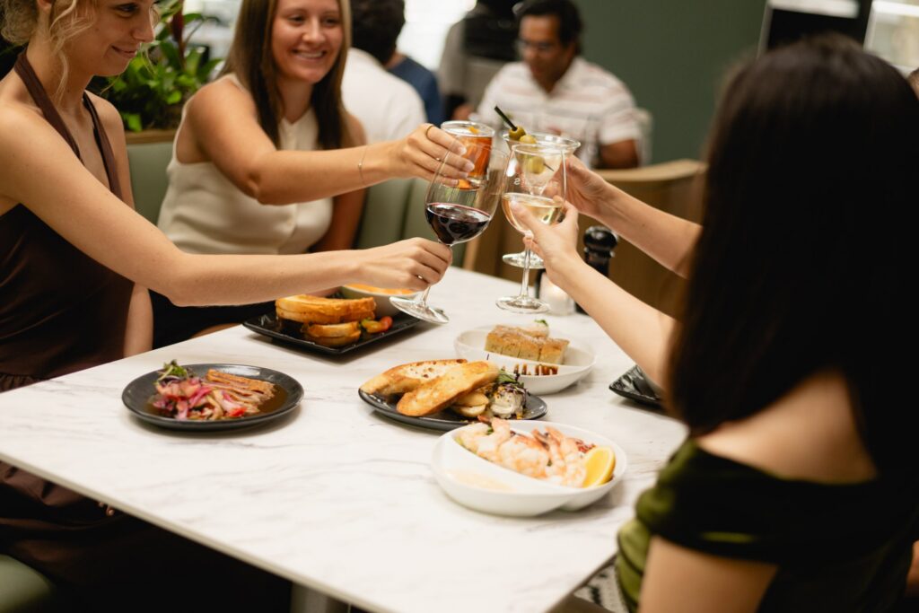 Friends raising a glass over charcuterie at Tucci's